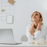 Woman taking a break from looking at her computer, stressed and frustrated.